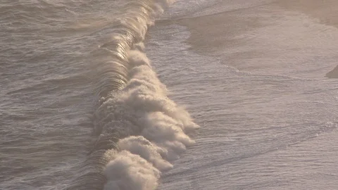 Waves breaking in slowmotion sunset Stock Footage 112615313