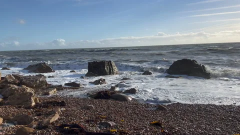 Waves breaking on a stone beach Stock Footage 239657776