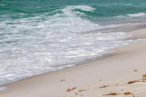 Waves breaking at a white sand beach. Stock Photos