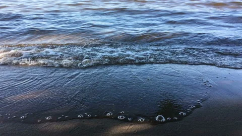 Waves with bubbles on a sandy beach. The concept of calm, happiness and Video stock 115796087