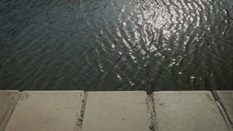 Waves on calm water surface against the Parapet of a embankment. 스톡 동영상 146010676