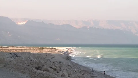 Waves on a coast with a mountain in the background Stock Footage 73667227