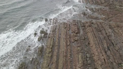 Waves collide with rocky beach and the grassy landscape Video stock 185928367