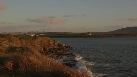 Waves come into beach with lighthouse in background. Stock Footage 201526709