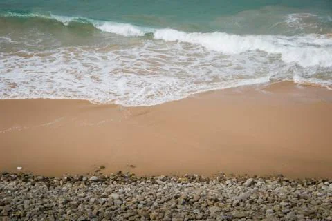 Waves coming ashore on sand Stock-Fotos