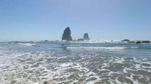Waves coming in with rock formation in background Stock Footage 92456112