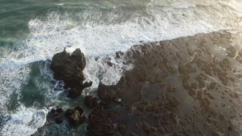 Waves coming towards rocks drone shot Stock Footage 303629907