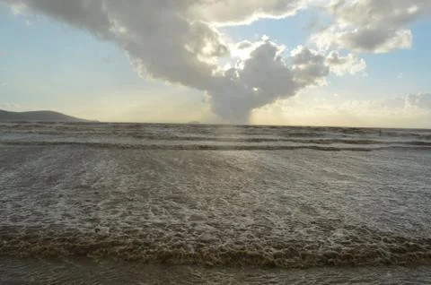 Waves comming in on beach, V shape in clouds Stock Photos