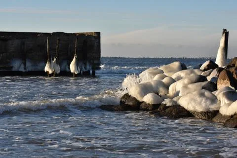 Waves crahing on icy rocks Stock Photos