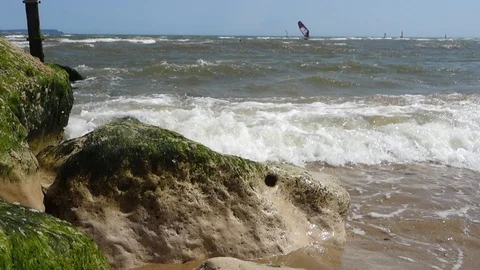 Waves crash against a boulder on Avon Beach, UK Stock Footage 112616448
