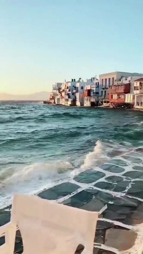 Waves crash against the dock at a tavern in Mykonos during sunset. Vídeos de archivo 335081709