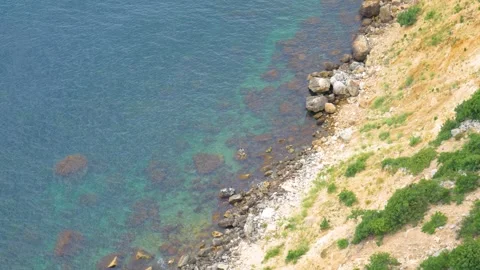 The waves crash against a large rock, view from above. Stock Footage 246086363