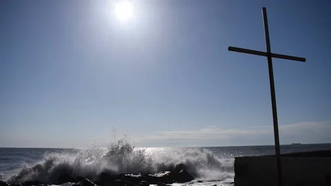 Waves crash against the rocks on the background of the cross Stock Footage 185655899