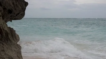 Waves crash against rocks on a beach in Bali. Video stock 86010035