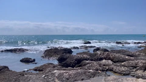 Waves crash against rocks at beach, sea spray. Ocean wave motion, stone coast. Stock Footage 284435334