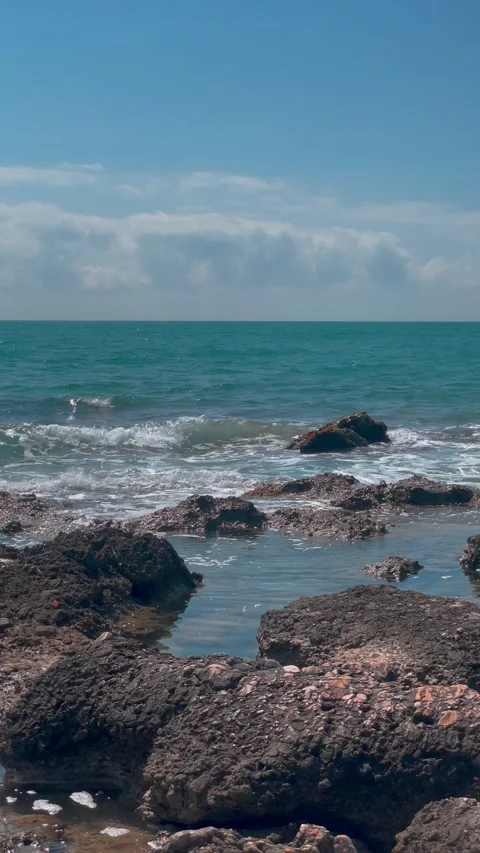 Waves crash against rocks at beach, sea spray. Ocean wave motion, stone coast. Vidéo 287737511