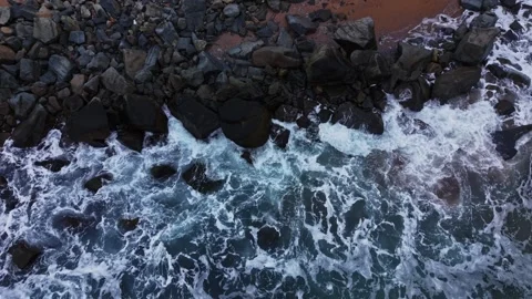 Waves crash against rocks on a beach during daylight hours 库存影片 331296326