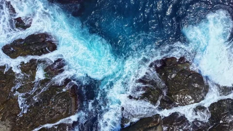 Waves crash against rocks in a coastal area during daylight hours Stock Footage 343551758