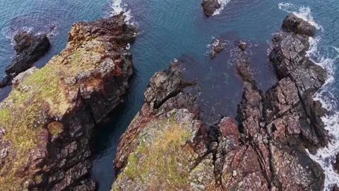 Waves crash against rocks at the coastline during daylight hours 스톡 동영상 335142947
