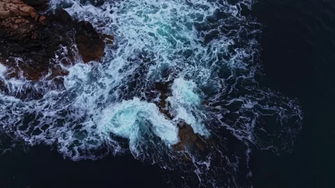 Waves crash against rocks in the ocean during sunset Vídeos de archivo 331296932