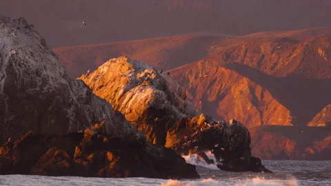 Waves Crash Against Rocks at Sunset Video stock 184259020
