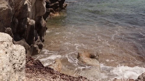 Waves crash against rockss on the beach. Blue water of the mediterranean sea Stock Footage 120245244