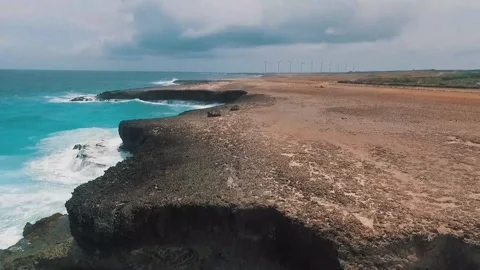 Waves crash against rocky cliffs in a remote coastal area Video stock 320304530