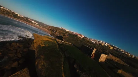 Waves crash against rugged cliffs below Stock Footage 339787845