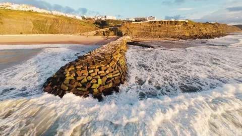 Waves crash against rugged coastal rocks with crashing energy Stock Footage 340913945