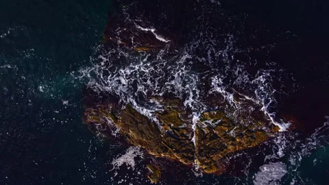 Waves crash against rugged rocks at twilight as nature's beauty unfolds in a Stock Footage 331955355