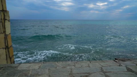Waves crash against the sandy stone shore Stock Footage 242022890