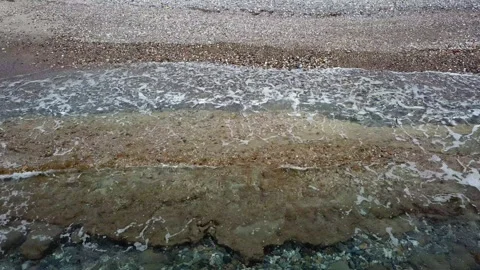 Waves crash against the sandy stone shore Stock Footage 242023341
