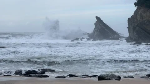 Waves crash against a sharp sea stack in the Oregon Coast Stock Footage 329448813