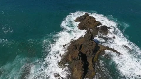The waves crash against a small volcanic island. Rock formations of frozen lava Stock Footage 219288944