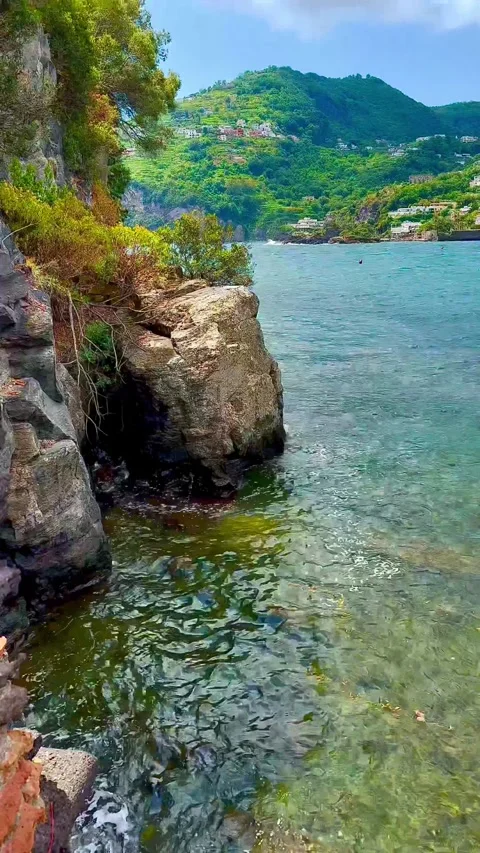 Waves crash against a stone wall and a cliff. The Tyrrhenian Sea. Stock Footage 310519868