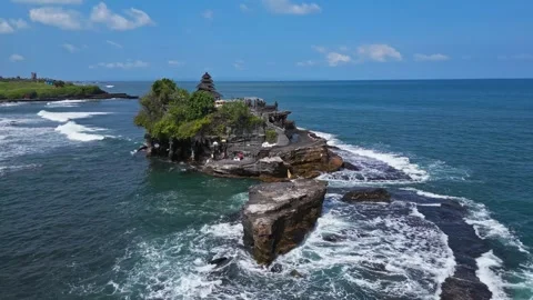 Waves crash and dance around its rugged base, Tanah Lot, aerial parallax Stock Footage 280395627