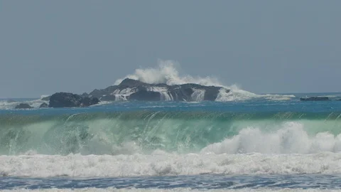 Waves crash on beach and rocks in the distance Stock Footage 108880891