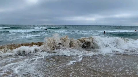 Waves crash at the beach on a cloudy day, 4K Stock Footage 128329497