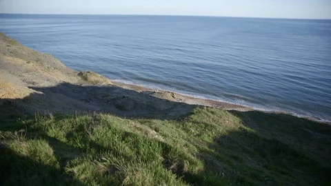 Waves crash onto beach in Dorset. The sand is golden and the sun is starting to Stock Footage 112022096