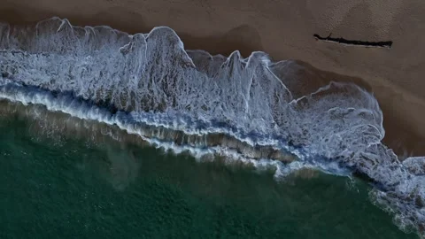 Waves crash on beach seen from the sky Stock Footage 299573201