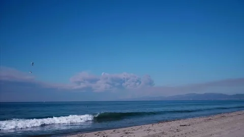 Waves Crash on Beach as Wild Fire Burns Stock Footage 98119690