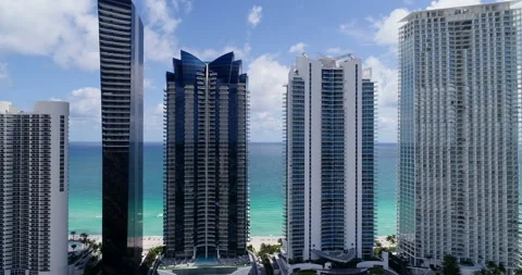 Waves crash behind the Sunny Isle towers Stock Footage 149707435
