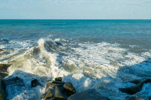 Waves crash on breakwaters. Stock Photos