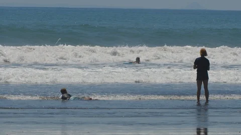 Waves crash down behind some boogey boarders Stock Footage 108884494