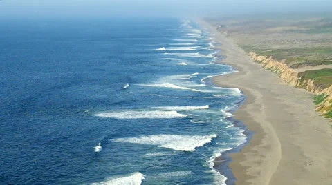 Waves crash on empty beach which seems to stretch off forever into mist Stock Footage 47167080