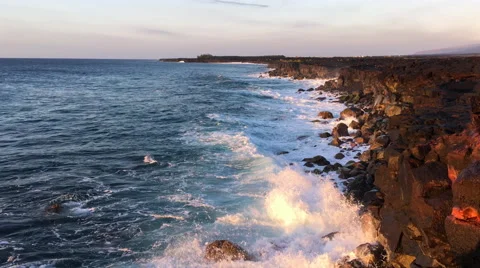 Waves crash on golden cliffs at sunrise, coastline in perspective (4K) Stock Footage 61156701