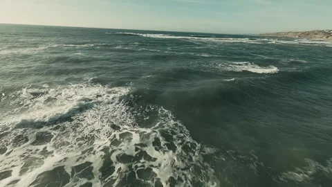 Waves crash onto golden sands below Video stock 341826108