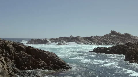 Waves crash into jagged edge of coastal area around Canal Rocks Stock Footage 344289747
