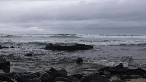 Waves crash into the lava rocks on the beach with small ball in water 스톡 동영상 81638788