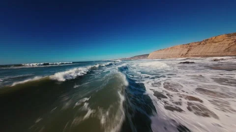 Waves crash over sand, foam swirls, sky glows deep blue Stock Footage 339786034